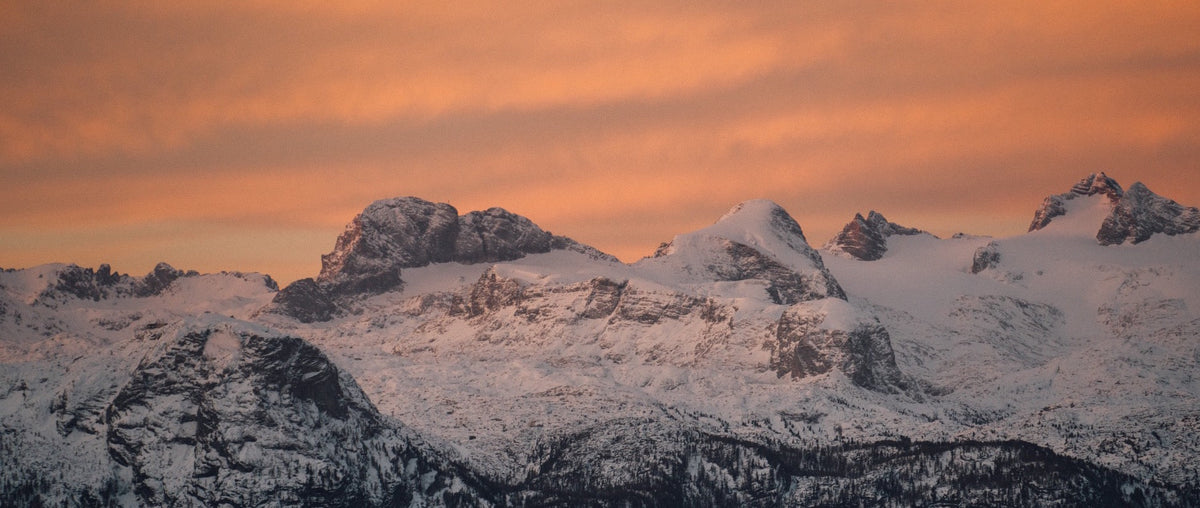 A snowy mountain landscape at sunrise