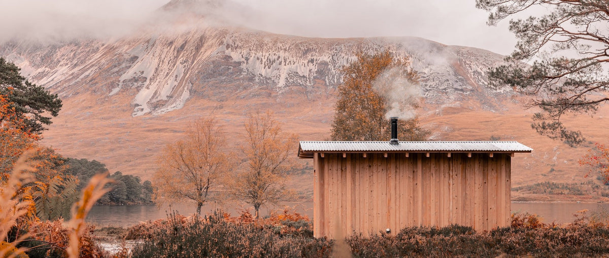 A sauna out in a remote area surrounded by mountains and trees