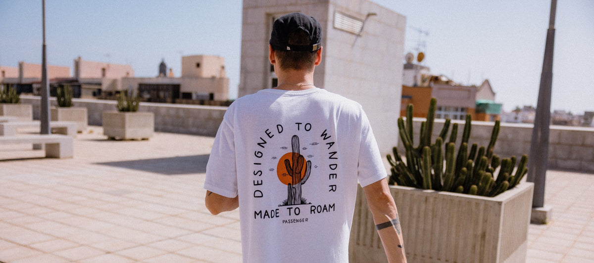 A man with his back to the camera walking along a rooftop